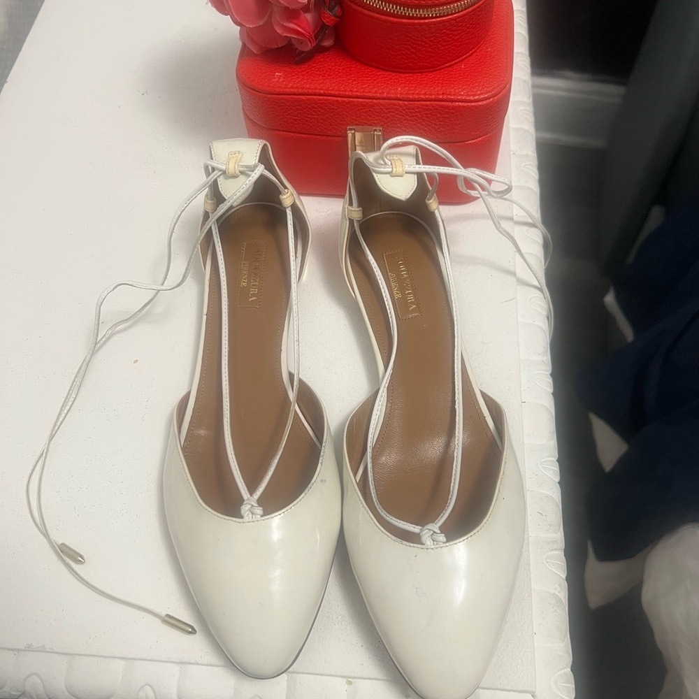 Aquazzura, “Christy” lace up ballet flats white patent leather.